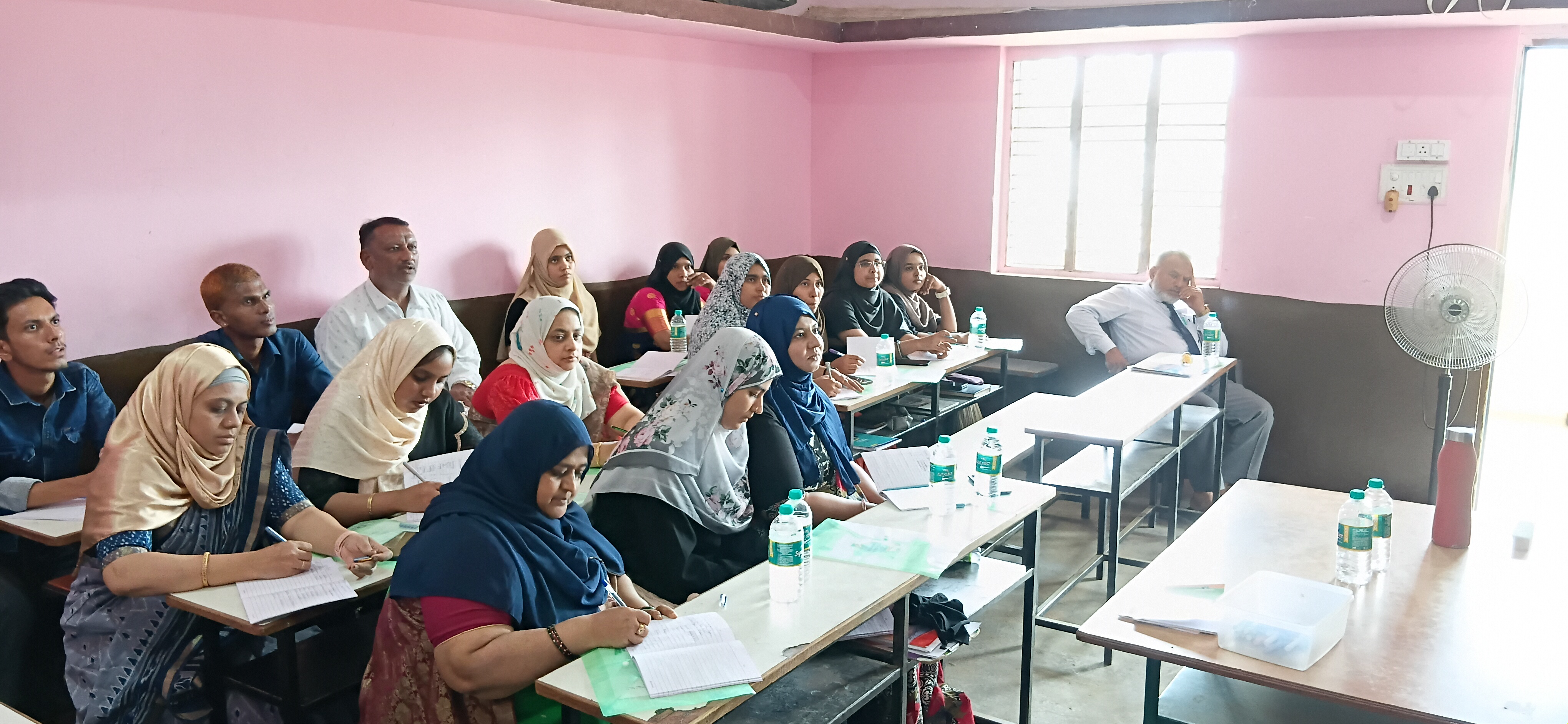 Full classroom of participating teachers taking notes